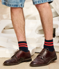 Man wearing classic brown shoes with red and navy striped ankle socks crafted from cotton yarns made in Portugal