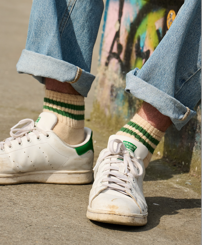 Man wearing Stan Smith shoes with Ecru and green striped ankle socks crafted from cotton yarns made in Portugal