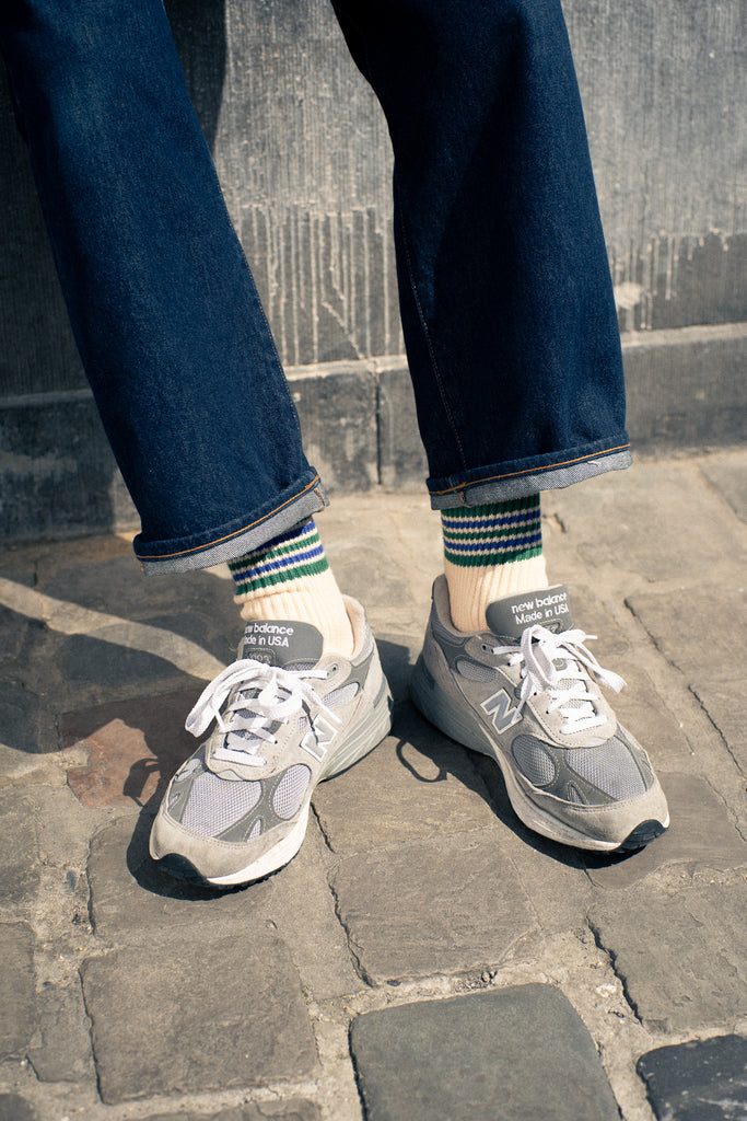 Person wearing stripes socks from Escuyer brand with New Balance sneakers