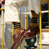 Man wearing yellow and pink striped crew socks by Escuyer, made in Portugal