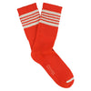 A pair of orange socks with five white stripes on the cuff and the brand name ' Escuyer ' on the foot area.