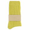 A pair of yellow cashmere crew socks with a brand tag attached to the ankle.