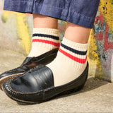 Woman wearing Escuyer striped ankle socks Red / Ochre with black loafers — spring summer style