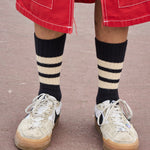Man wearing orange and ecru striped crew socks by Escuyer, made in Portugal