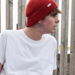 Person wearing an orange ribbed merino wool beanie by Escuyer