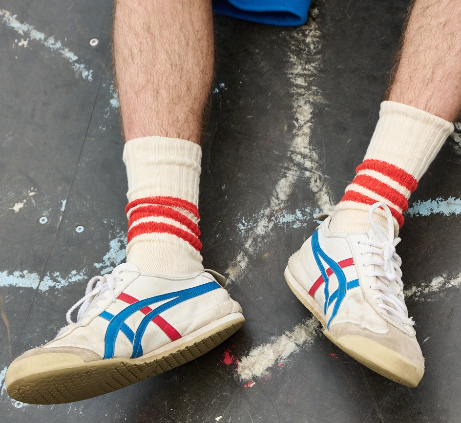 Man wearing ecru and orange striped crew socks by Escuyer, made in Portugal