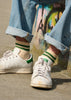 Man wearing Stan Smith shoes with Ecru and green striped ankle socks crafted from cotton yarns made in Portugal
