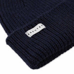 Side view of navy ribbed merino wool beanie with folded cuff